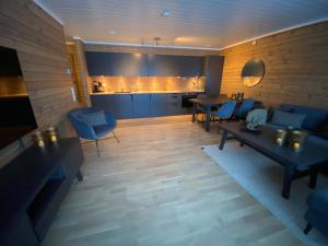 ein Wohnzimmer mit blauen Möbeln und eine Küche in der Unterkunft New modern apartment with great view - ski in & out in Skulestadmo