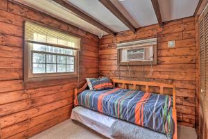 a bedroom in a log cabin with a bed and a window at Rustic Lake Harmony Home with Fire Pit and Hot Tub! in Lake Harmony