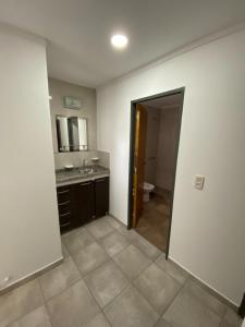 Habitación con baño con lavabo y espejo. en Raices Departamento 2 en San Rafael