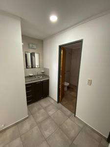 una habitación con un baño con lavabo y espejo en Raices Departamento 2, en San Rafael