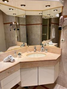bagno con lavandino e grande specchio di Comfy, cosy, and spacious apartment near Paris a Bezons