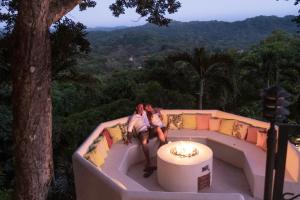 a man and a woman sitting on a couch at Tierra Magnifica Boutique Hotel in Nosara