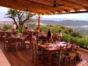 a group of people sitting at tables on a deck at Tierra Magnifica Boutique Hotel in Nosara