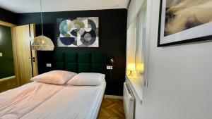 a bedroom with a bed and a green wall at Apartamenty Karkonoska Dolina in Staniszów