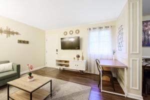 a living room with a couch and a table at Dapper Digs - King Bed - Long Term Stays - Duke in Durham +21 photos
