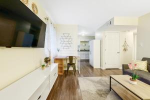 a living room and kitchen with a couch and a table at Dapper Digs - King Bed - Long Term Stays - Duke in Durham