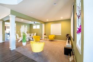 a living room with yellow chairs and a table at Utopia Luxury Stay in Puyallup
