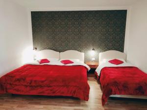 duas camas num quarto de hotel com capas vermelhas em Hotel Fenicia em Roma