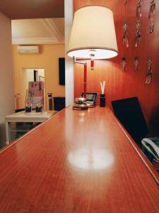 une grande table en bois dans une chambre avec une lampe dans l'établissement Hotel Fenicia, à Rome