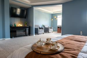 a room with a bed with a tray with tea cups on it at Utopia Luxury Stay in Puyallup