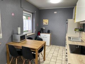 Erft Apartment في كيربن: مطبخ مع طاولة وكراسي في مطبخ