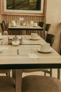 una mesa con sillas, platos y vasos. en Alas Hotel en San Rafael