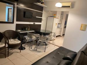 a living room with a couch and a table and chairs at Apartamento com 2 quartos no centro de Pipa in Pipa