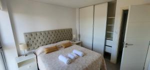 1 dormitorio con 1 cama y 2 toallas blancas en Gama Top con cochera en Córdoba