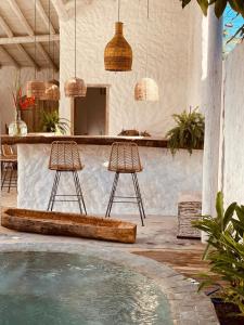 un patio con 2 sgabelli da bar e una piscina di Pousada Villa Cacau a Trancoso