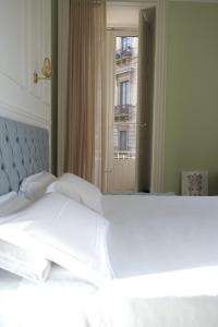 a bedroom with a white bed with a large mirror at Toscano Palace Luxury Rooms Catania in Catania