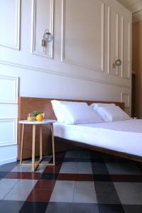 a bedroom with a bed and a table at Toscano Palace Luxury Rooms Catania in Catania