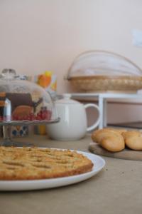 a table with a pie and a plate of food at Toscano Palace Luxury Rooms Catania in Catania