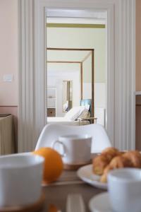 a table with a plate of pastries and a mirror at Toscano Palace Luxury Rooms Catania in Catania