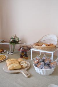 a table with bread and pastries and a basket of food at Toscano Palace Luxury Rooms Catania in Catania