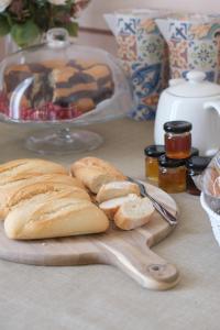 a group of bread on a cutting board with a plate of bread at Toscano Palace Luxury Rooms Catania in Catania