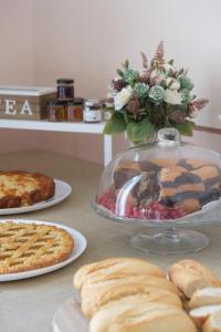a table topped with plates of food and pies at Toscano Palace Luxury Rooms Catania in Catania