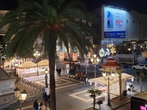 a palm tree on a city street at night at Toscano Palace Luxury Rooms Catania in Catania