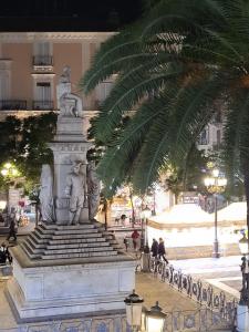a statue in the middle of a street with a palm tree at Toscano Palace Luxury Rooms Catania in Catania