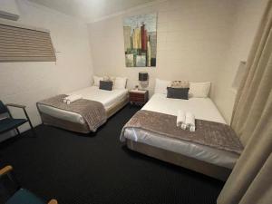 A bed or beds in a room at Dalby Hotel Motel