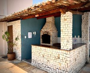 an outdoor brick pizza oven in a building at Aconchegantes Flats, 1 e 2 qtos, em Ponta Negra in Natal