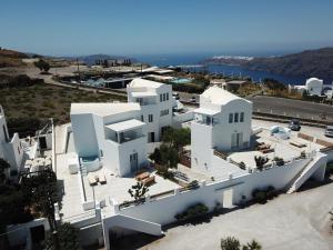 una vista aérea de un edificio blanco con el océano en el fondo en Athiri Santorini Hotel, en Imerovigli