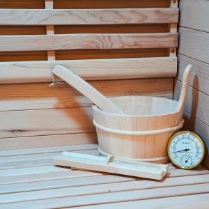 a wooden bucket and a clock next to books at Toscano Palace Luxury Rooms Catania in Catania
