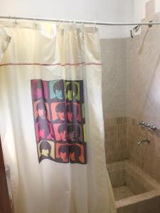 a bathroom with a shower curtain and a tub at Chalet de montaña cerca de Nono in Las Rabonas