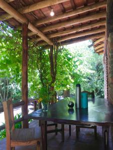 a wooden table on a porch with a wooden roof at Chalet de montaña cerca de Nono in Las Rabonas