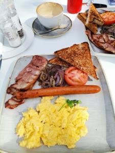 a plate of food with scrambled eggs and bacon at Masingitana Greater Kruger Safaris in Utlha