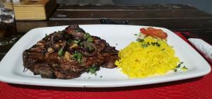a plate of food with steak and rice on a table at Masingitana Greater Kruger Safaris in Utlha