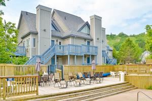 Casa grande con terraza con sillas y mesas. en Condo 110 at North Creek Resort, en Blue Mountains