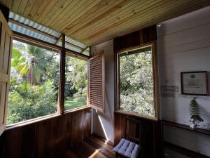 a room with two large windows in a house at Old Bocasso in Bocas del Toro