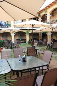an outdoor patio with tables and chairs and umbrellas at Hotel Casa Realeza in Antigua Guatemala