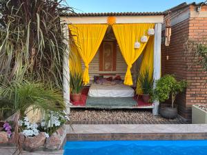 ein Bett in einem Haus mit gelbem Baldachin in der Unterkunft PAZ Y ARMONÍA en chuy 2 in Chuy