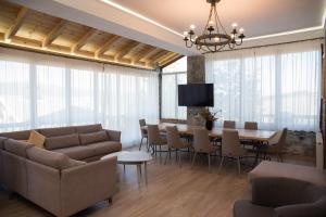 - un salon avec un canapé, une table et des chaises dans l'établissement Luxury Villa Saint Nikolas, à Voskopojë