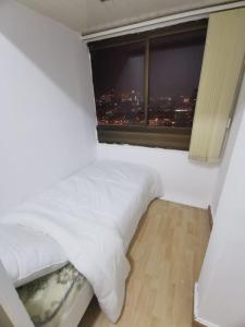 a white bed in a room with a window at Cloud9 hostel in Dubai