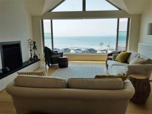 sala de estar con sofá y vistas al océano en Beached Again, en Point Lonsdale