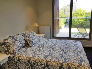 a bedroom with a bed and a large window at Beached Again in Point Lonsdale