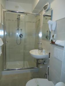 y baño con ducha, aseo y lavamanos. en Albergo Ristorante K2 en Abetone