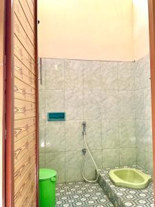 a bathroom with a shower with a green tub at Villa Sakana - Escape to Paradise in Balong