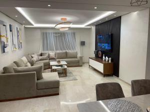 a living room with a couch and a tv at Luxury Modern Apartment in the heart of Marrakesh. in Marrakech