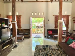a living room with a couch and a television at Villa Sakana - Escape to Paradise in Balong
