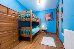 une chambre avec un lit superposé et des murs bleus dans l'établissement The Byre, à Goodleigh