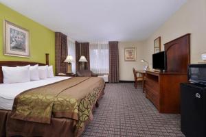 a hotel room with a bed and a flat screen tv at Regency Inn Geneseo IL I-80 in Geneseo